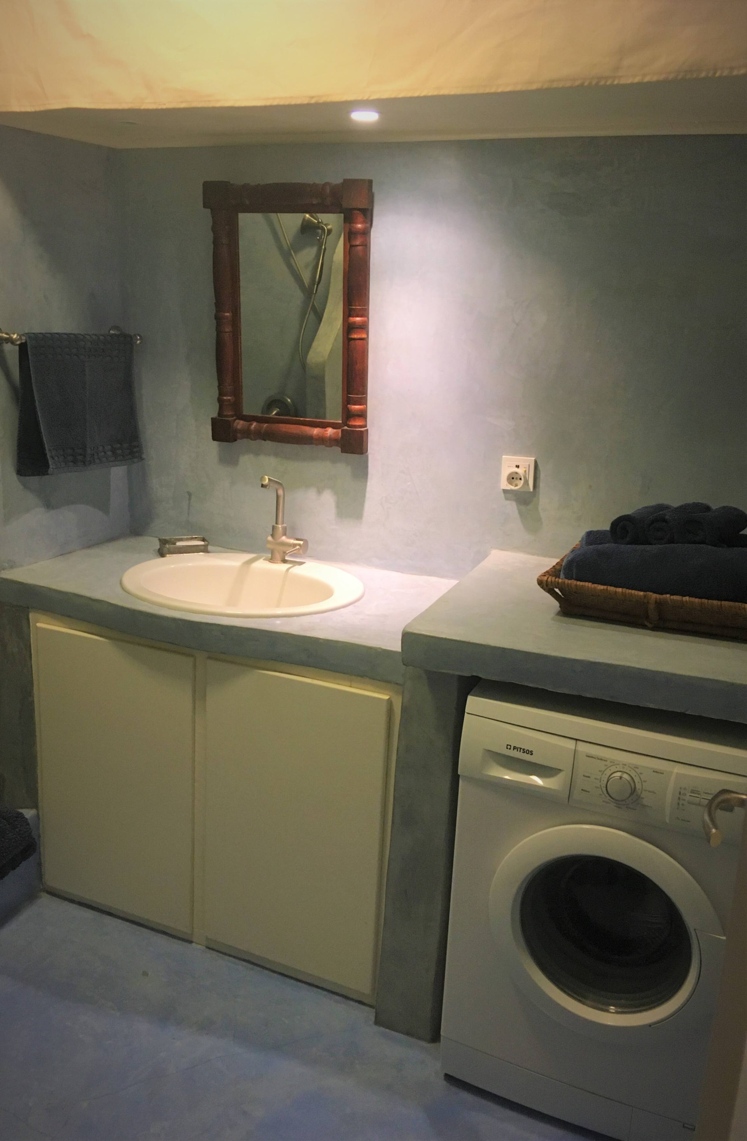 Blue bathroom with vanity and laundry area